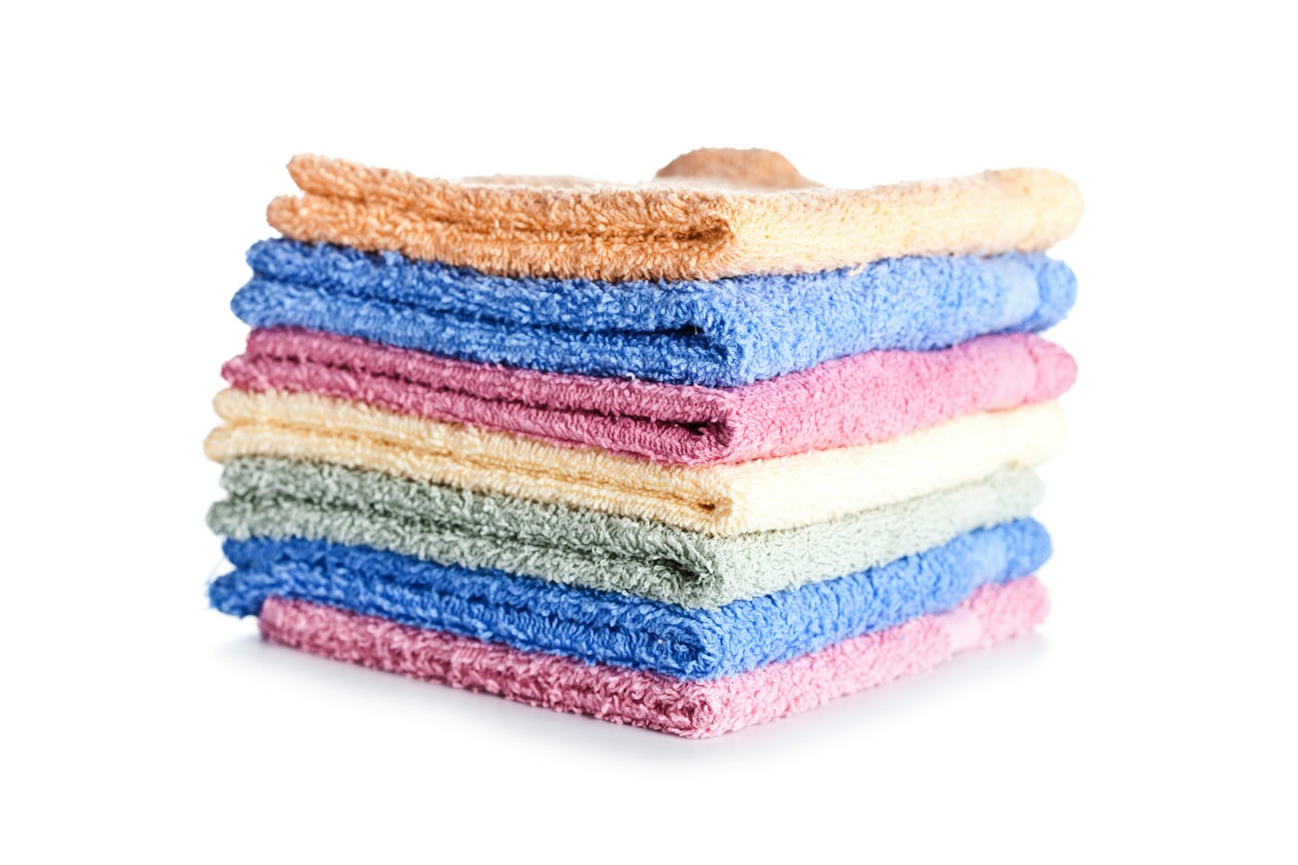 Una pila alta di asciugamani piegati ordinatamente in colori pastello.